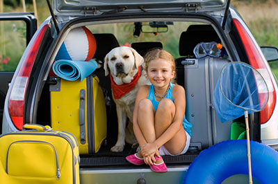 Child and her pet in the back of a car